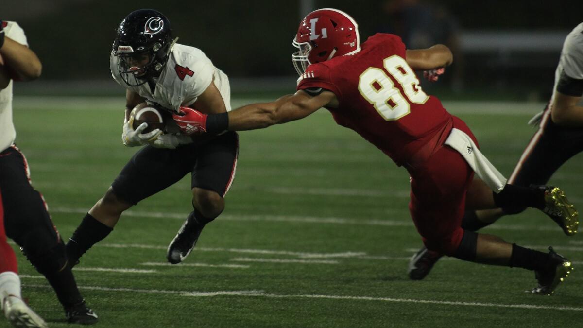 Orange Lutheran defensive lineman Ethan Nae (88) reaches out to tackle Corona Centennial running back Octavio Cortes.