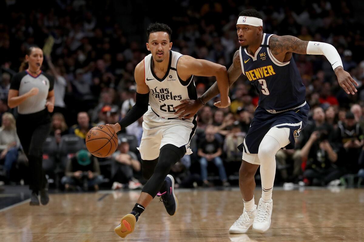 Clippers guard Landry Shamet brings the ball down the court against Denver's Torrey Craig on Sunday at Pepsi Center.