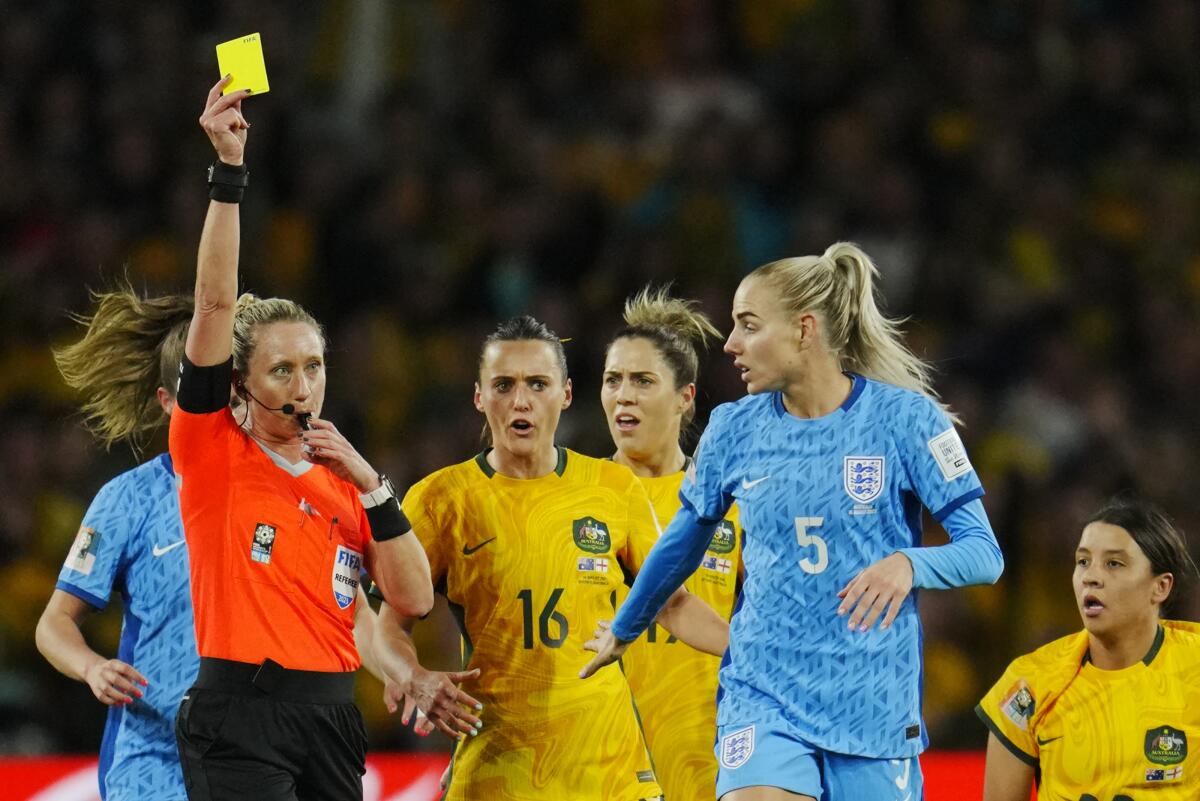 Referee Tori Penso shows a yellow card to England's Alex Greenwood during a Women's World Cup semifinal match.