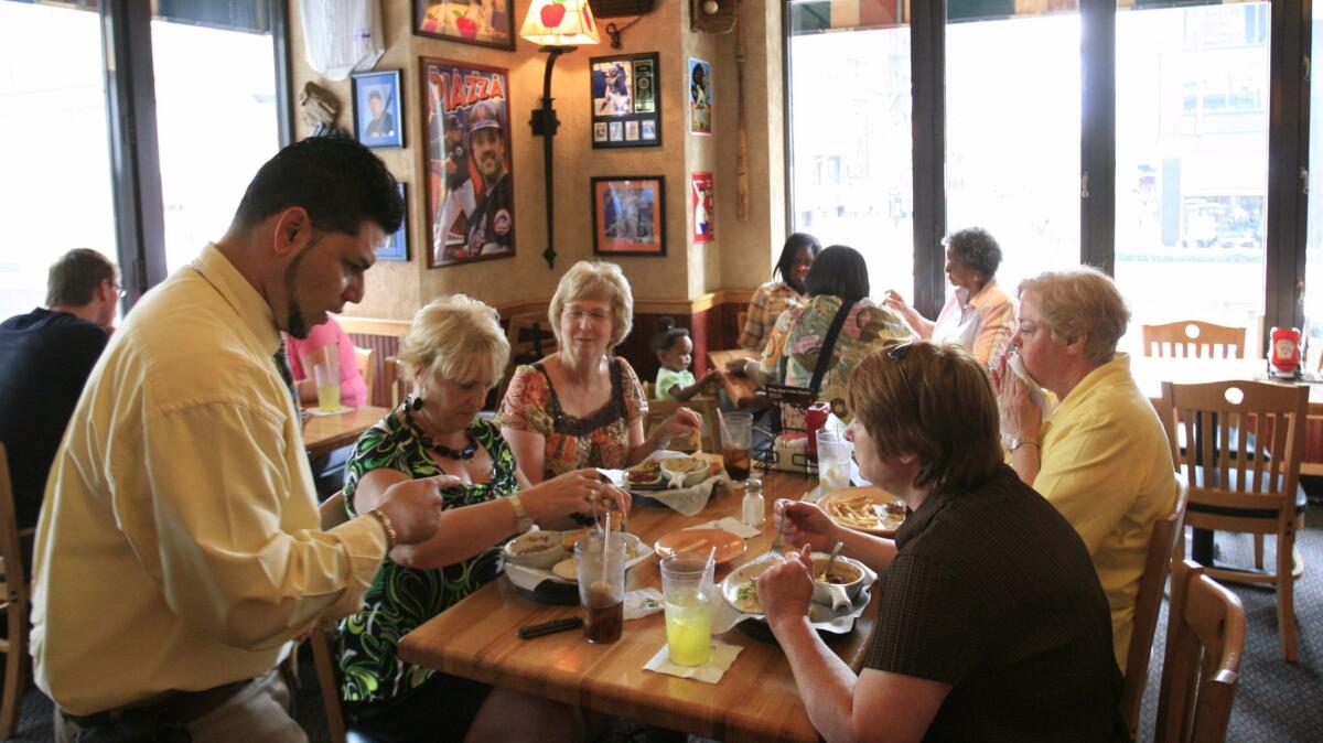 In this 2009 file photo, customers enjoy lunch at an Applebee's in New York. DineEquity said Thursday it could close up to 160 Applebee's and IHOP locations, but it will open dozens of new restaurants.