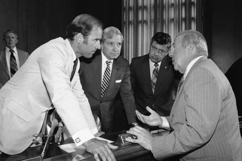 Secretary of State designate George Shultz, right, has a few words with members of the Senate Foreign Relations Committee prior to the start of the afternoon session of the panel on Capitol Hill in Washington on Tuesday, July 13, 1982 which is holding his confirmation hearings. From left are: Sens. Joseph Biden, D-Del.; Charles Percy of Ill., chairman of the panel and Edward Zorinsky, D-Neb. (AP Photo/Ira Schwarz)