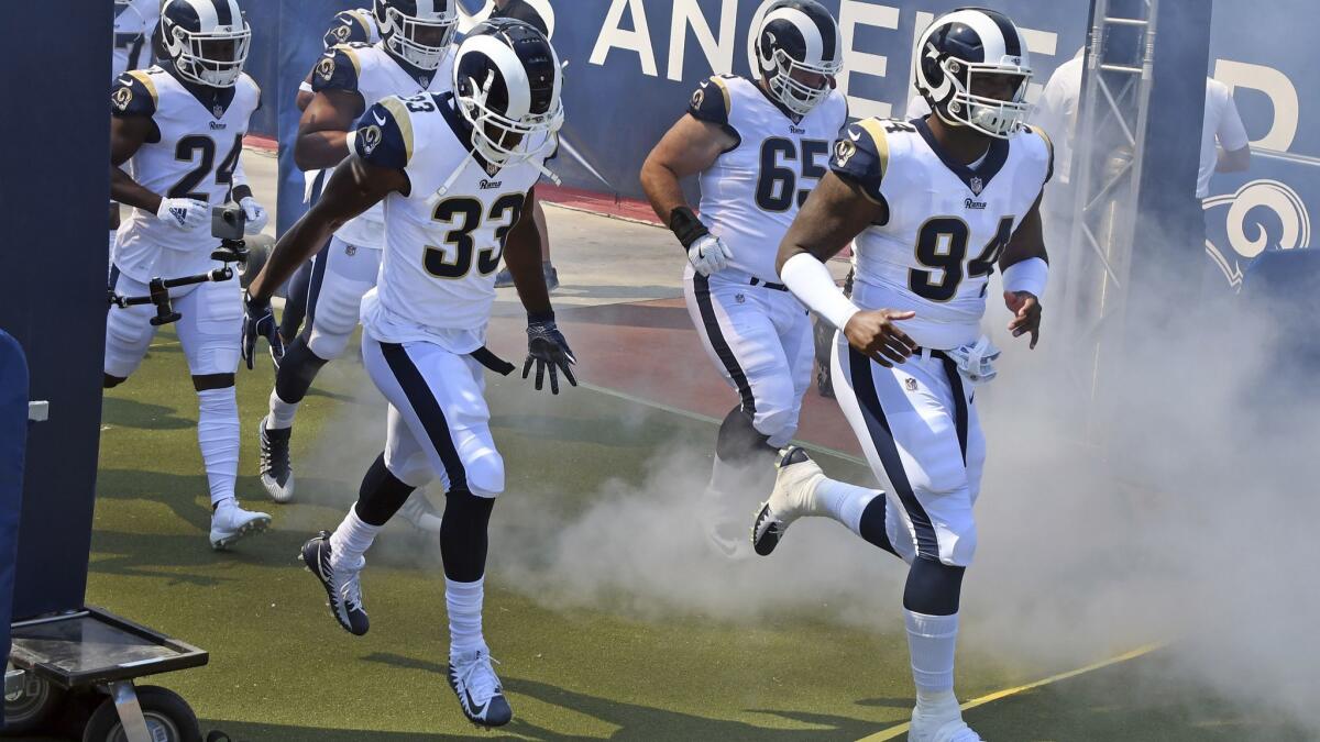 Rams running back Justin Davis (33) and defensive lineman John Franklin-Myers (94) head onto the field with their teammates before a game against the Chargers on Sept. 23.
