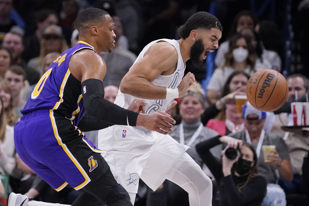 The Lakers' Russell Westbrook, left, and the Thunder's Kenrich Williams chase a loose ball Dec. 10, 2021.
