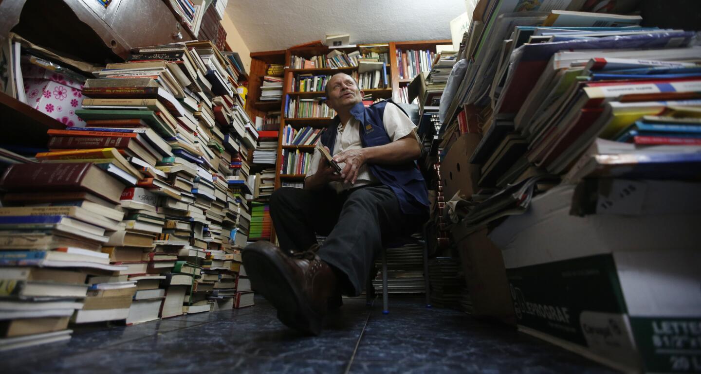 En esta imagen, tomada el 19 de agosto de 2015, José Alberto Gutiérrez posa sentado en medio de pilas de libros en su casa de Bogotá, en Colombia. El hecho de haber estudiado sólo hasta segundo de primaria no ha sido obstáculo para que Gutiérrez haya dedicado los últimos 16 años de su vida a rescatar libros de la basura, que luego presta o regala a niños y jóvenes más pobres.