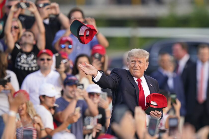 Former President Donald Trump throws 'Save America" hats to the audience before speaking at a rally at the Lorain County Fairgrounds, Saturday, June 26, 2021, in Wellington, Ohio. (AP Photo/Tony Dejak)