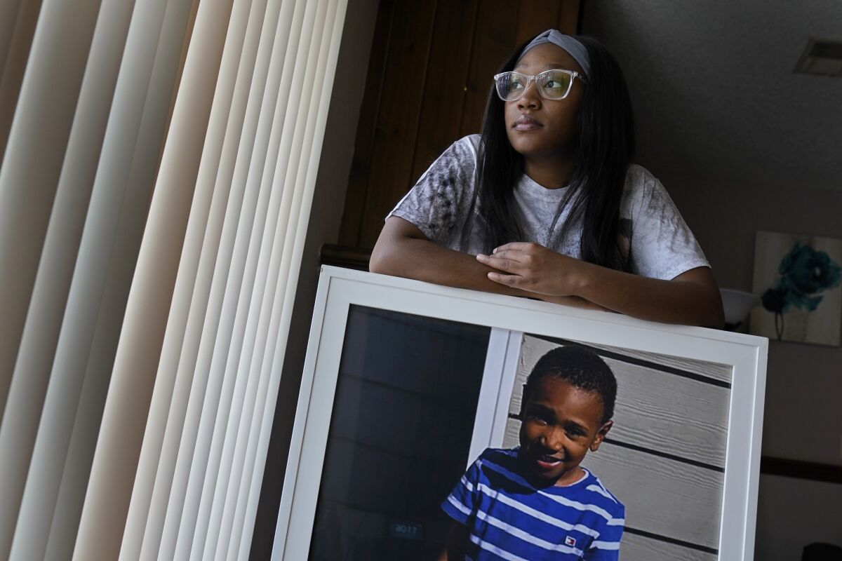 Charron Powell stands with a photo of her son, LeGend Talieferro, at her home in Raytown, Mo. on Sunday, Oct. 3, 2021. LeGend was 4 years old when he was fatally shot June 29, 2020 while he was sleeping in an apartment staying with his father. (AP Photo/Charlie Riedel)
