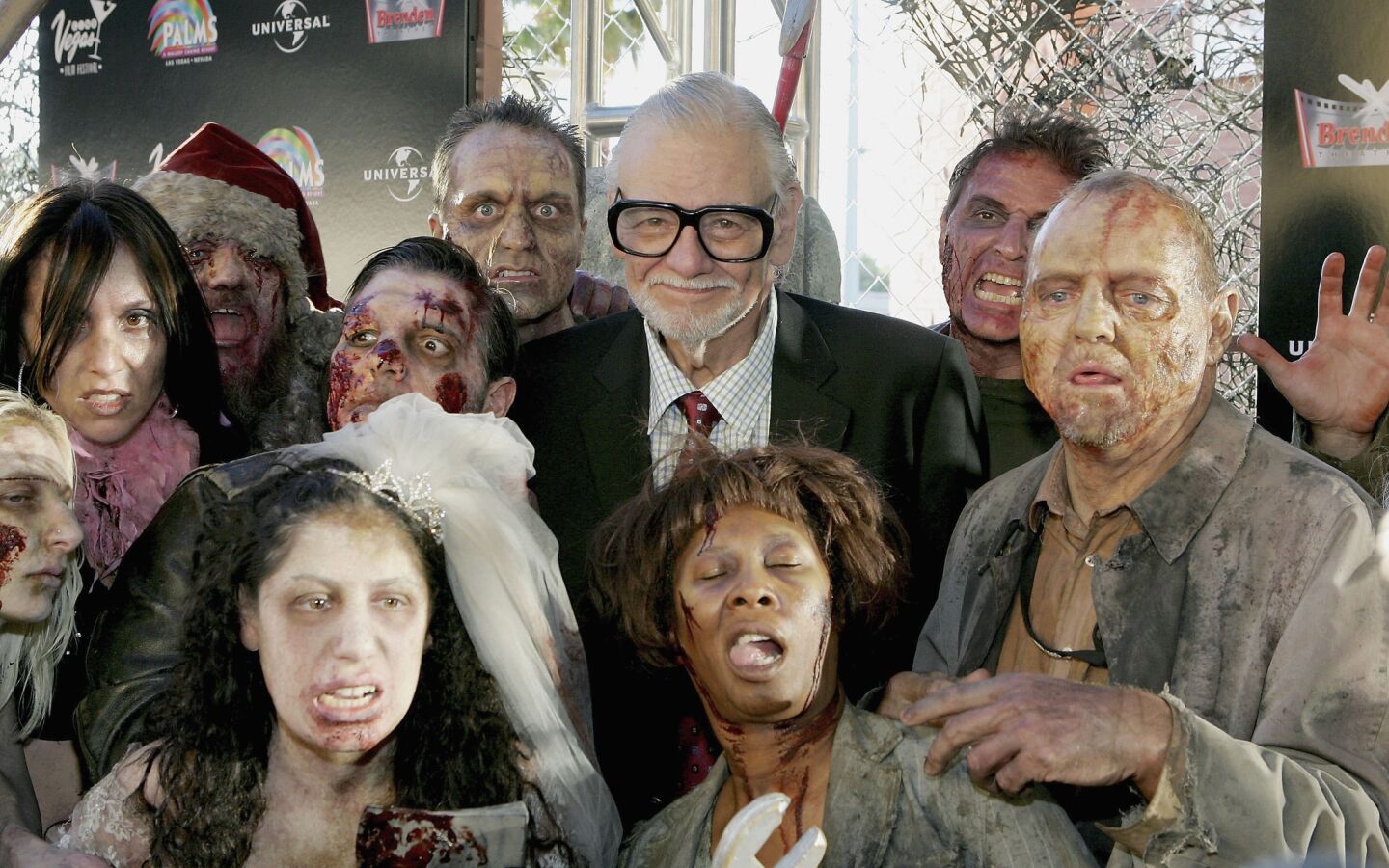 Director George Romero is surrounded by actors dressed as zombies at the world premiere of his movie "Land of the Dead" in Las Vegas in 2005.
