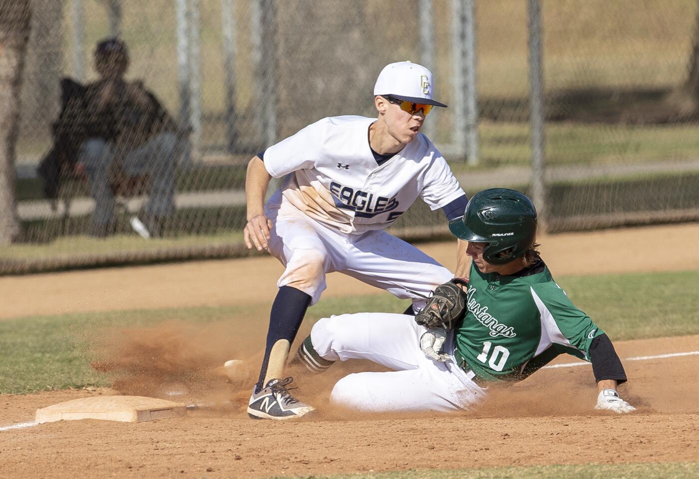 Costa Mesa's Riley Mitchell is tagged out at third by Calvary Chapel's Jake Esquivel during an Orange Coast League game on Tuesday, April 24.