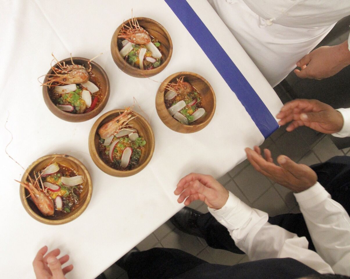 Servers wait to bring the Santa Barbara spot prawn dish by Roy Choi out to diners.