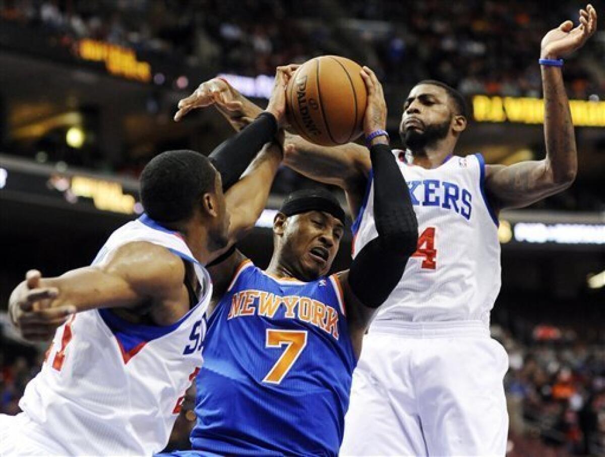 New York Knicks' Carmelo Anthony (7) drives between Philadelphia 76ers' Thaddeus Young (21) and Dorell Wright (4) in the first half of an NBA basketball game, Monday, Nov. 5, 2012, in Philadelphia. (AP Photo/Michael Perez)