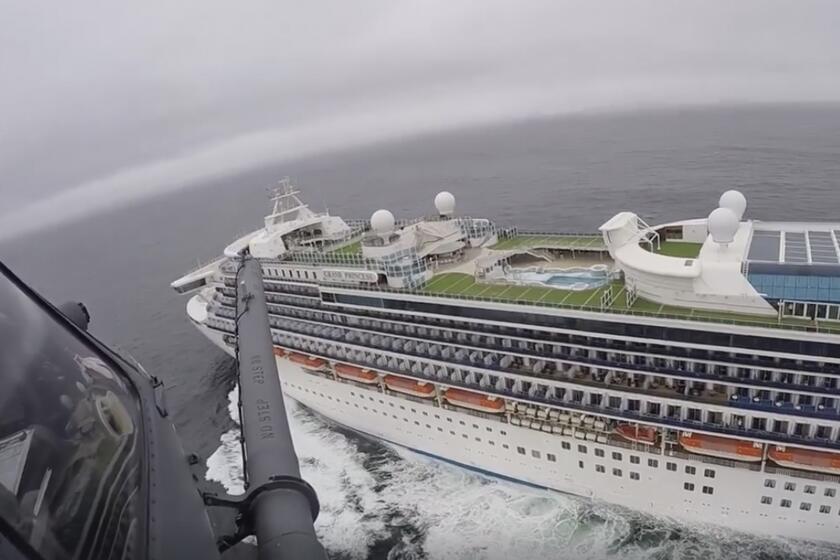 In this image from video, provided by the California National Guard, a helicopter carrying airmen with the 129th Rescue Wing flies over the Grand Princess cruise ship off the coast of California Thursday, March 5, 2020. Scrambling to keep the coronavirus at bay, officials ordered a cruise ship with 3,500 people aboard to stay back from the California coast Thursday until passengers and crew can be tested, after a traveler from its previous voyage died of the disease and at least two others became infected. Airmen lowered test kits onto the 951-foot (290-meter) Grand Princess by rope as the vessel lay at anchor off Northern California, and authorities said the results would be available on Friday. Princess Cruise Lines said fewer than 100 people aboard had been identified for testing. (California National Guard via AP)