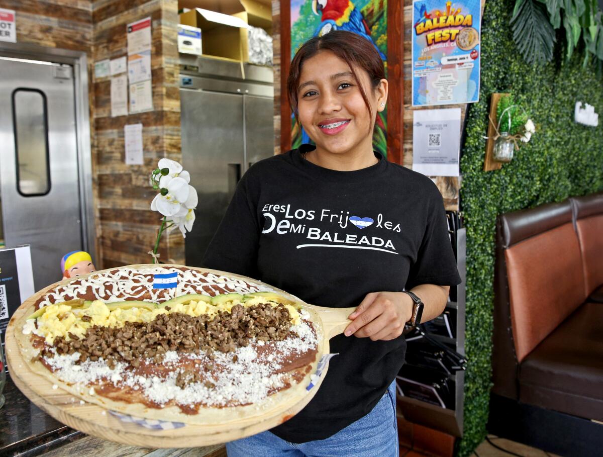 Kendry Escobar of Doña Bibis Restaurant shows off the Mega Baleada, at the restaurant on the 2400 block of W 7th St.