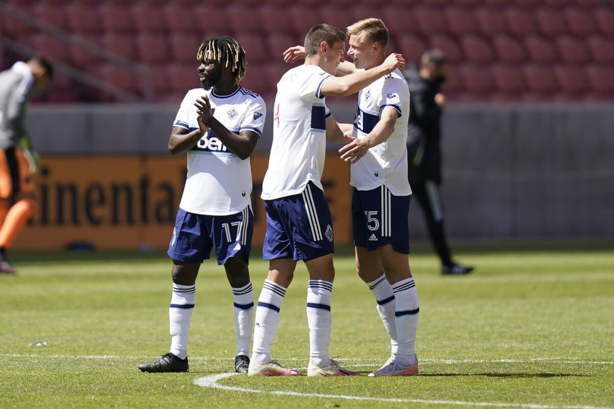 Vancouver Whitecaps' Leonard Owusu (17), Ranko Veselinovic, center, and Andy Rose (15) celebrate 