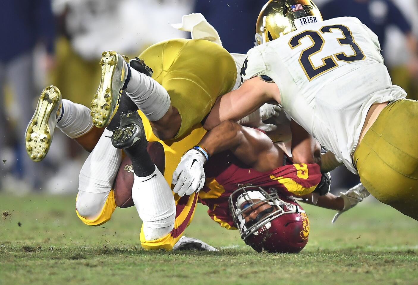 USC receiver Amon-Ra St. Brown fumbles after a reception as Notre Dame's Alohi Gilman makes the tackle and Drue Tranquill helps in the fourth quarter at the Coliseum. Notre Dame recovered the ball.