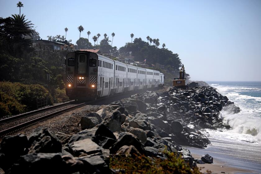 SAN CLEMENTE, CA - SEPTEMBER 26: Boulders are in place to protect the rail line and cliffs from further erosion along the coast at San Clemente State Beach on Monday, Sept. 26, 2022 in San Clemente, CA. The area, near the private community of Cypress Shores, now gets slammed by waves after years of sand loss and erosion swept away the beach buffer between the ocean and land, creating a vulnerable point in the rail system authorities are keeping a close eye on. (Gary Coronado / Los Angeles Times)