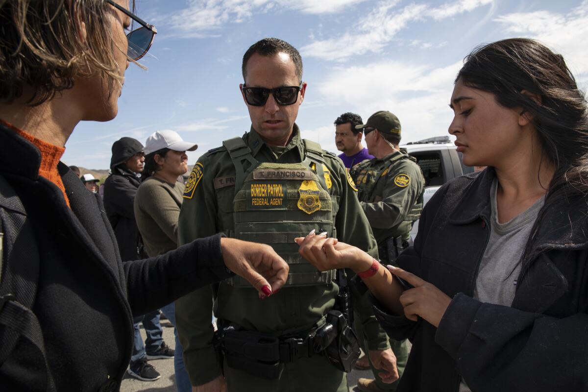  A woman from Brazil, left, and a woman from Colombia show their wrists bands 