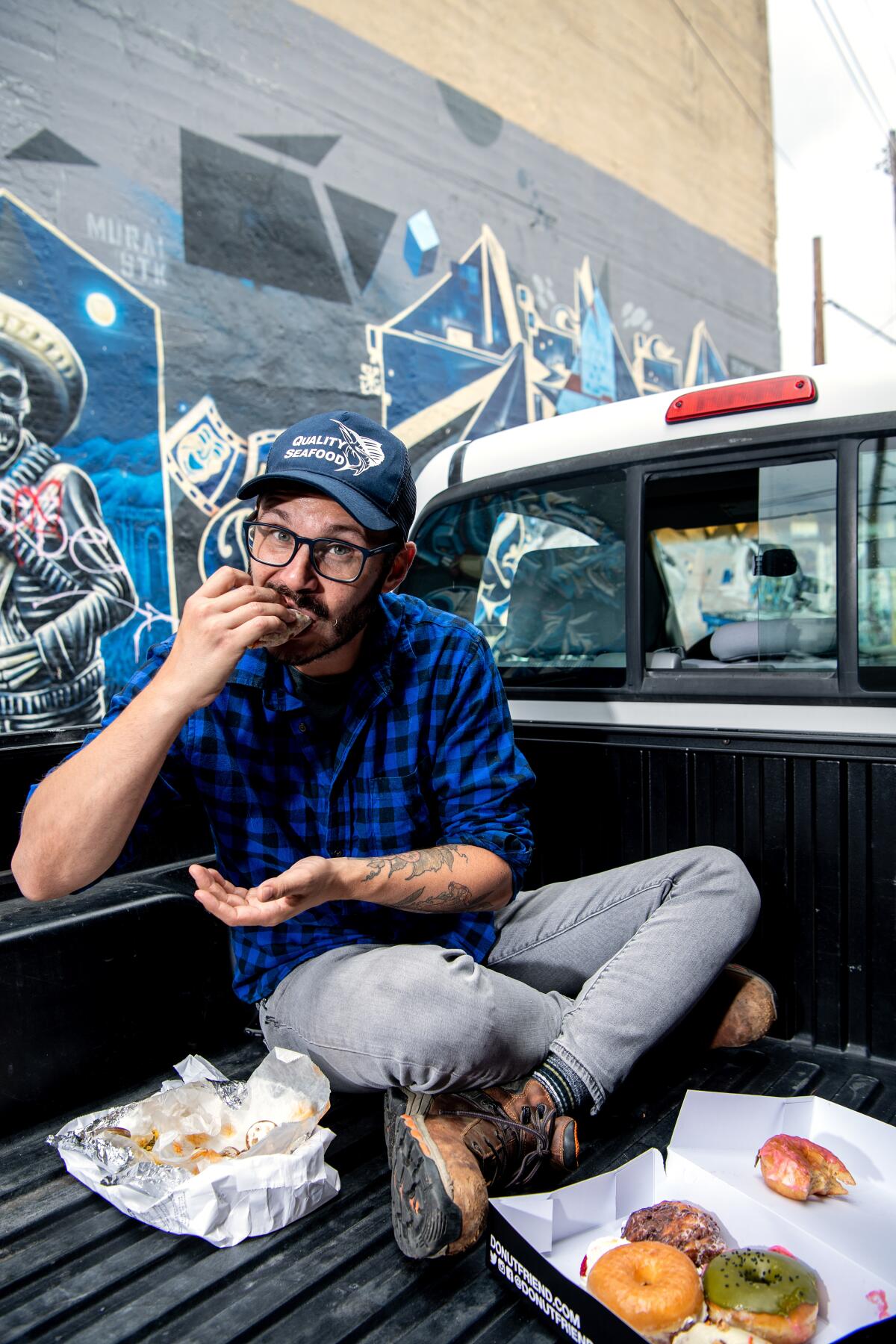 a man eats in the bed of a pickup truck