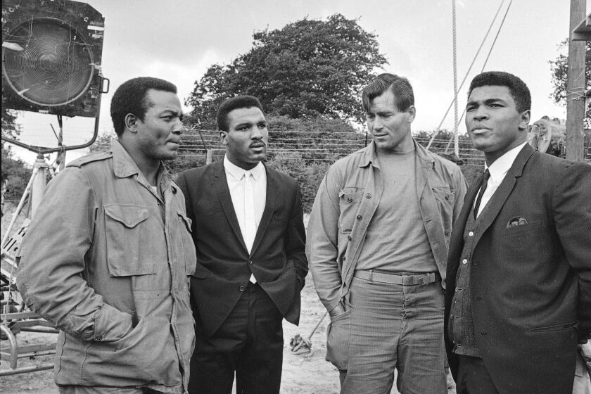 ARCHIV0 - Foto del 5 de agosto de 1966, Muhammad Ali visita el set de la película "The Dirty Dozen" con Jim Brown, Rahaman Ali y Clint Walker en Morkyate, Bedfordshire, Inglaterra. (AP Foto/Archivo)