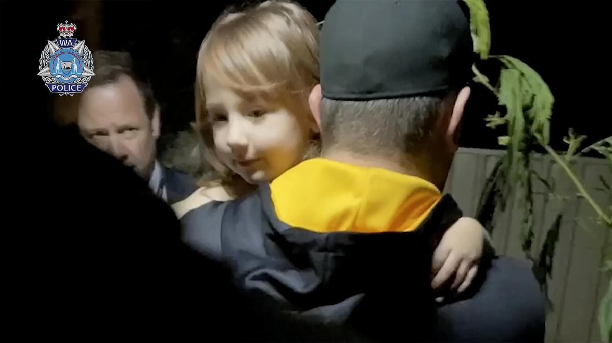 Police officer carrying young girl