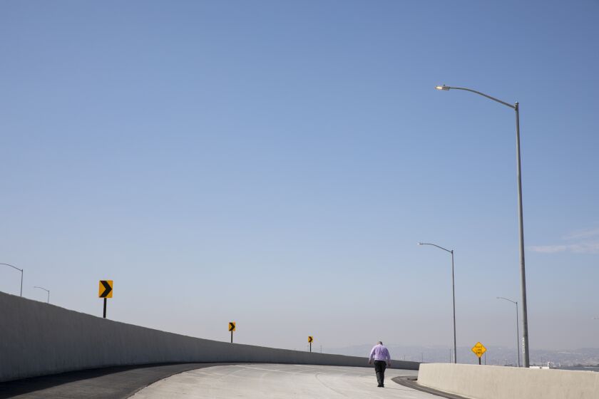 Otay Mesa, California - July 26: A person walks on a newly completed section of a freeway after a ribbon cutting on Tuesday, July 26, 2022 in Otay Mesa, California. The southbound State Route 125 to westbound State Route 905 will improve mobility throughout the region. The next project will be a new port of entry which is expected to be completed by 2024. (Ana Ramirez / The San Diego Union-Tribune)