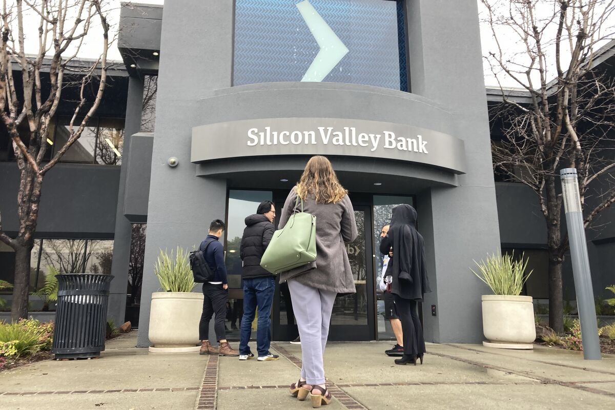 People stand outside an entrance to a Silicon Valley Bank branch in Santa Clara, Calif., on March 10. 