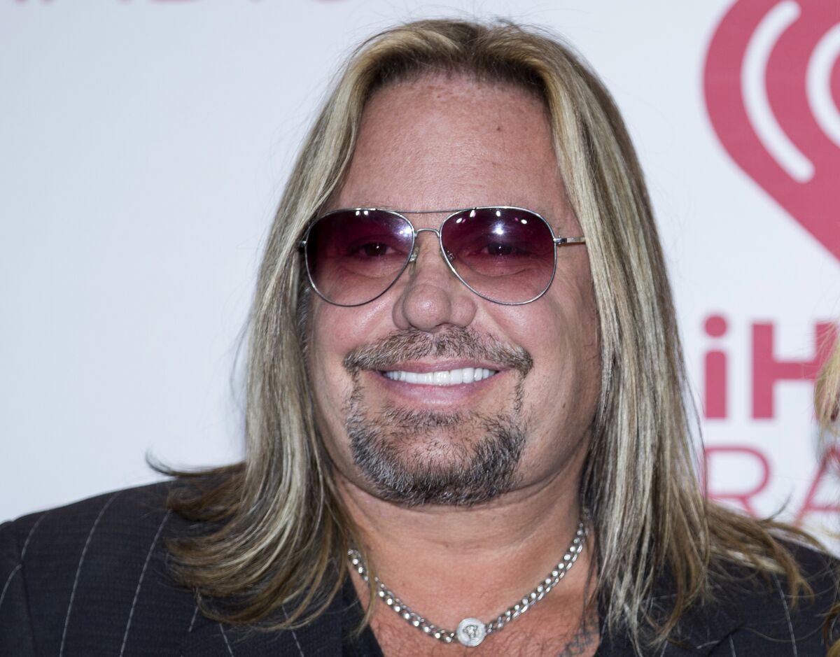 FILE - In this Sept. 19, 2014, file photo, Vince Neil of Motley Crue, arrives at the iHeart Radio Music Festival in Las Vegas. Neil has broken ribs during a fall off the stage at a concert in Tennessee. In video footage from the performance Friday, Oct. 15, 2021, Neil can be seen clapping at the edge of the stage with his guitar strapped around him before his fall. (Photo by Andrew Estey/Invision/AP, File)