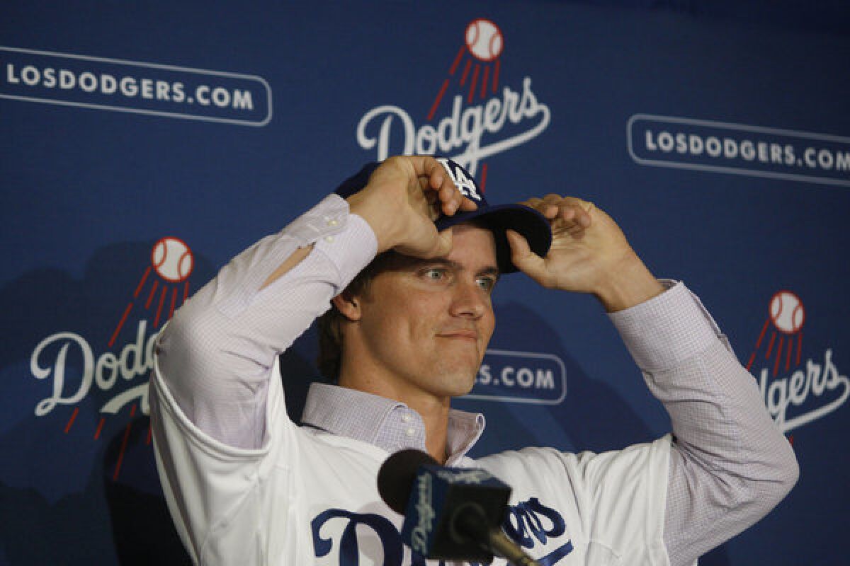 New Los Angeles Dodgers pitcher Zack Greinke adjusts his baseball cap at a press conference announcing his signing in December.
