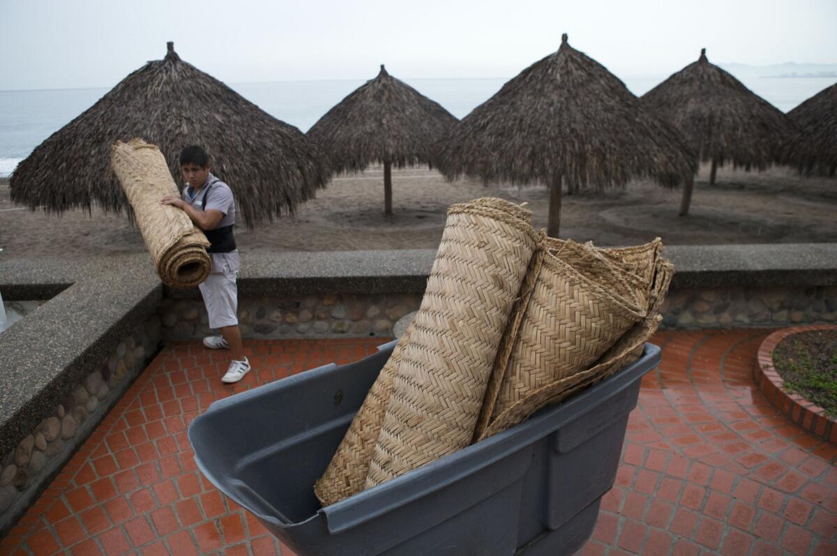An employee rolls up mats at a Sheraton beachfront hotel as staff prepare for the arrival on Friday of Hurricane Patricia in Puerto Vallarta, Mexico.