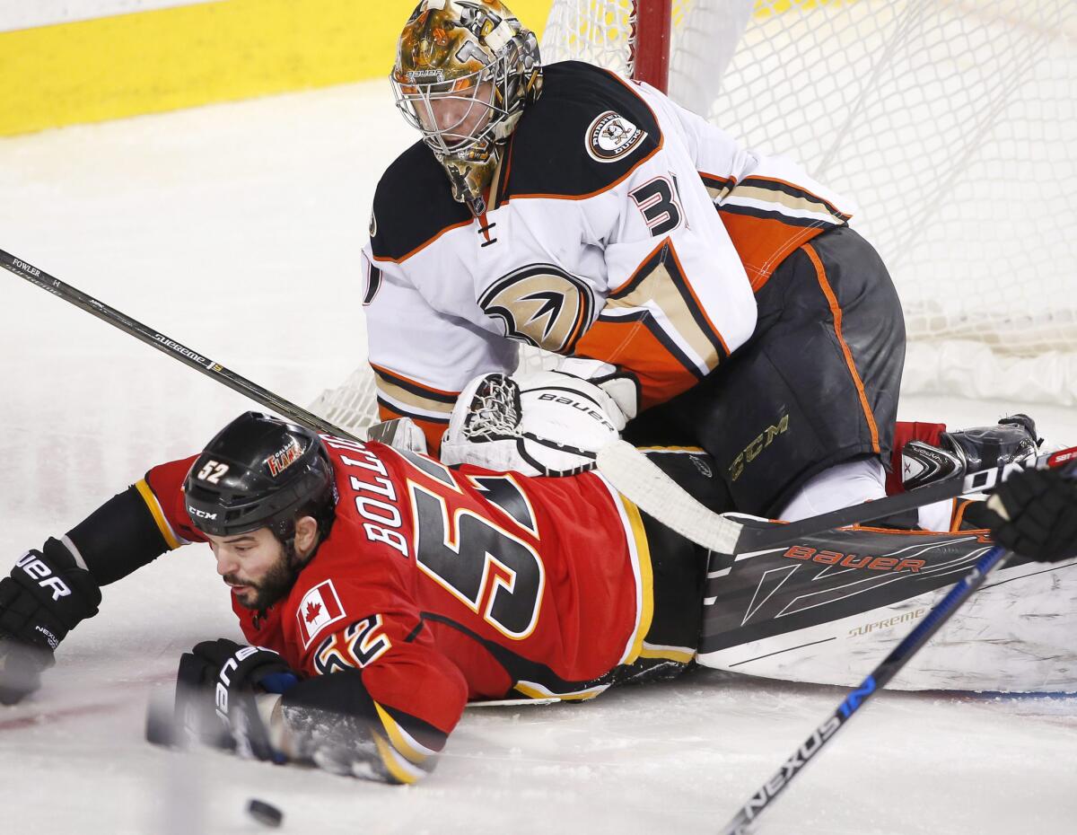 Ducks goalie Frederik Andersen watches he falls onto Flames forward Brandon Bollig during the third period.