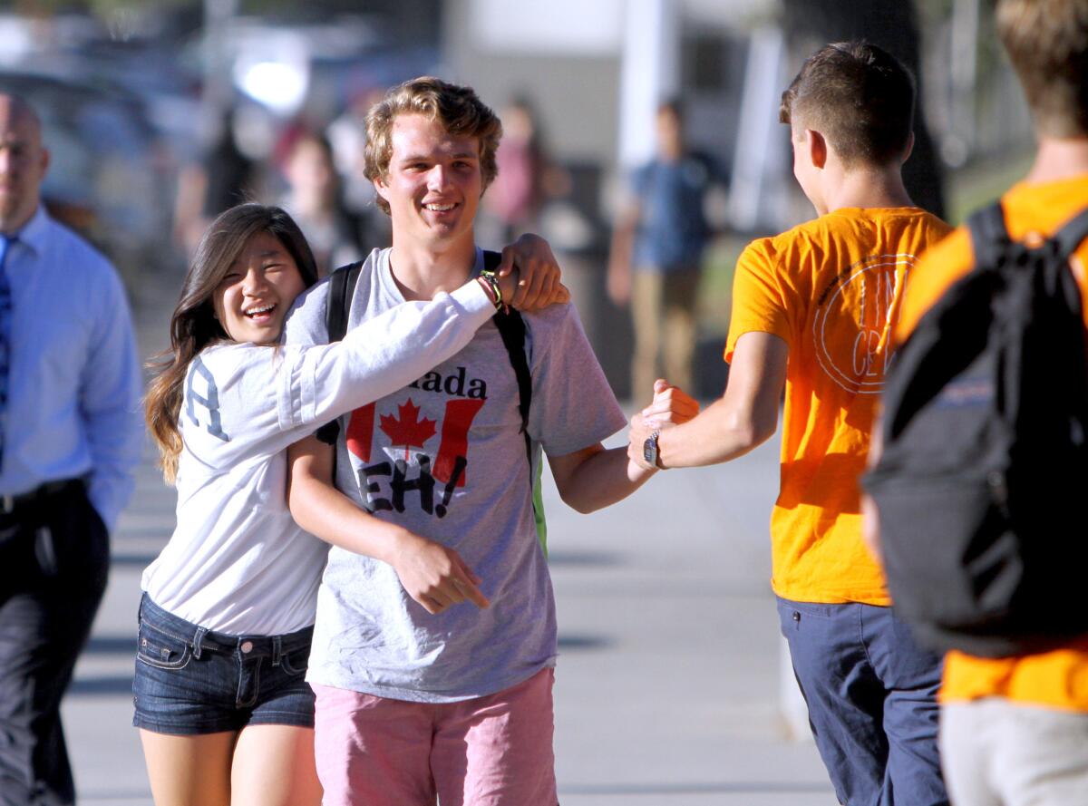 Recent La Cañada High School graduate Doyeon Kim, left, hugs senior Tomas Tuszynski on the first day of school at the La Cañada Flintridge high school on Tuesday, August 16, 2016.