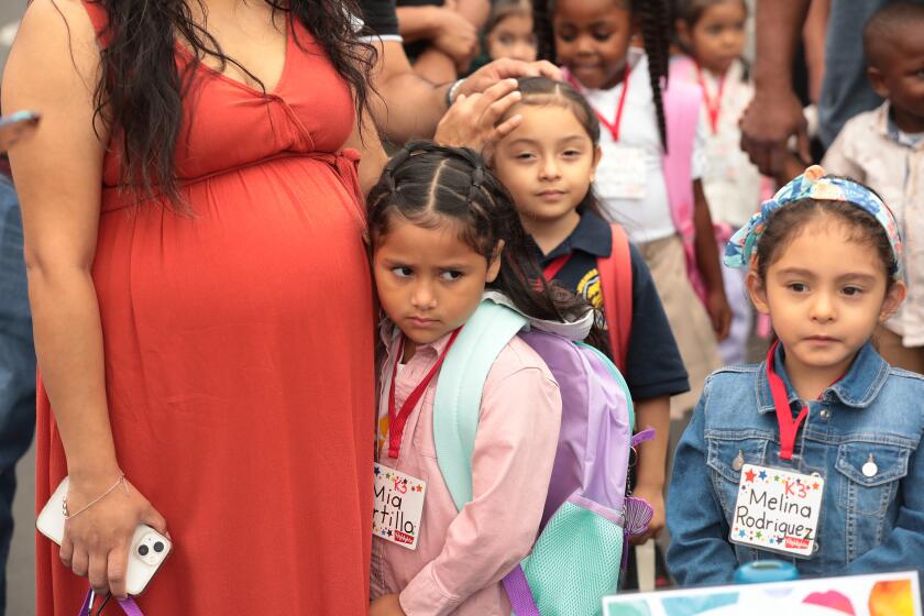 Los Angeles, CA - August 14: Lenicia B. Weemes Elementary School on Monday, Aug. 14, 2023 in Los Angeles, CA. First day of school TK (transitional kindergarten) student Melinda Rodriguez, right, is ready as her friend Mia Portillo is comforted by her Mother Daisy Salazar, left, as students assemble for the first day of school at Lenicia B. Weemes Elementary School on the first day of classes for LAUSD students. (Al Seib / For The Times)