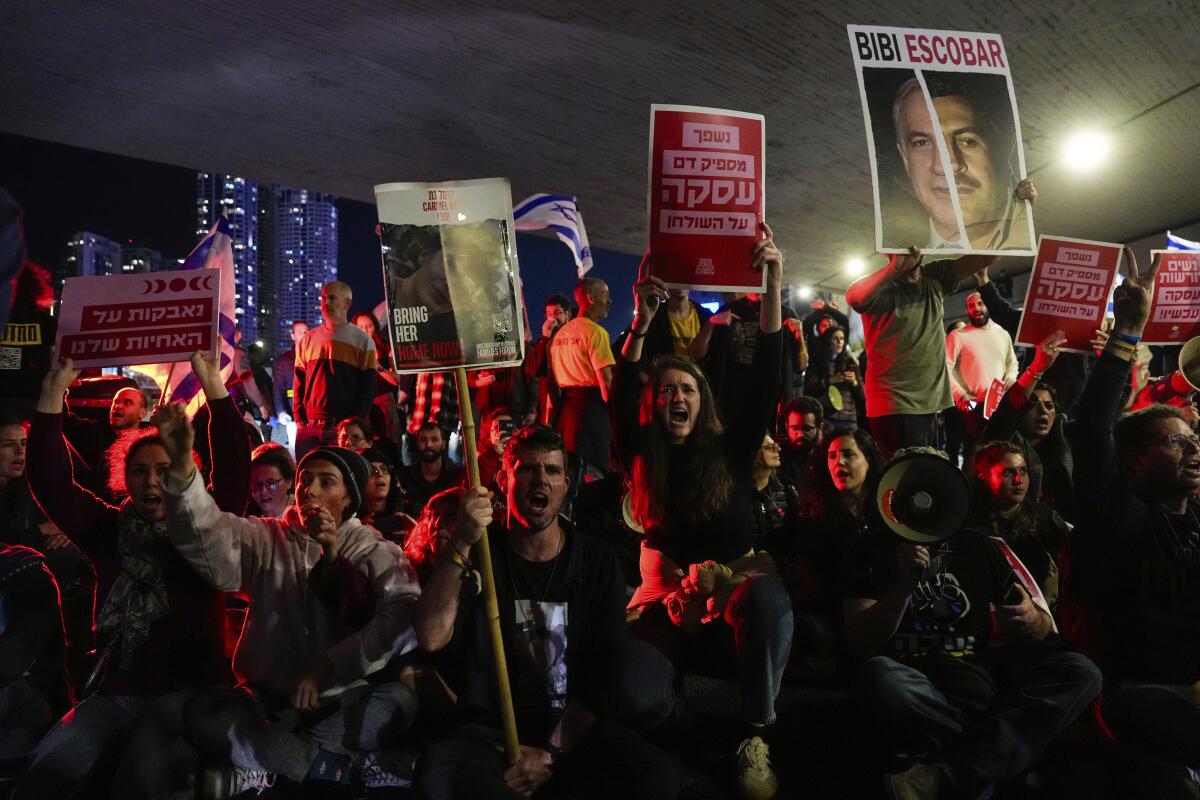 Protesters with signs block a road at night 