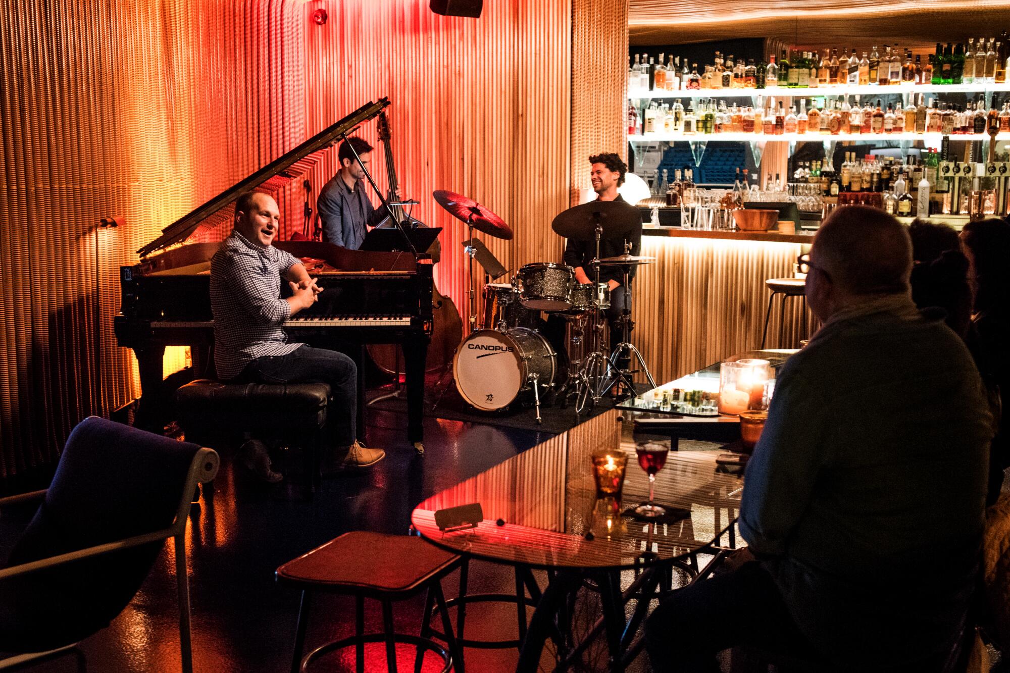 A group of jazz musicians sit with their instruments at a bar