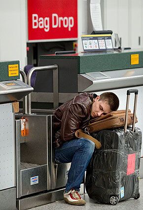 An airline passenger sleeps on his luggage at Gatwick Airport after flights across Europe were canceled because of a cloud of ash from the eruption of a volcano in Iceland.