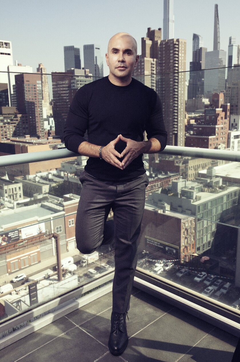 Chris McCarthy stands on a high-rise rooftop, with the New York City skyline in the background