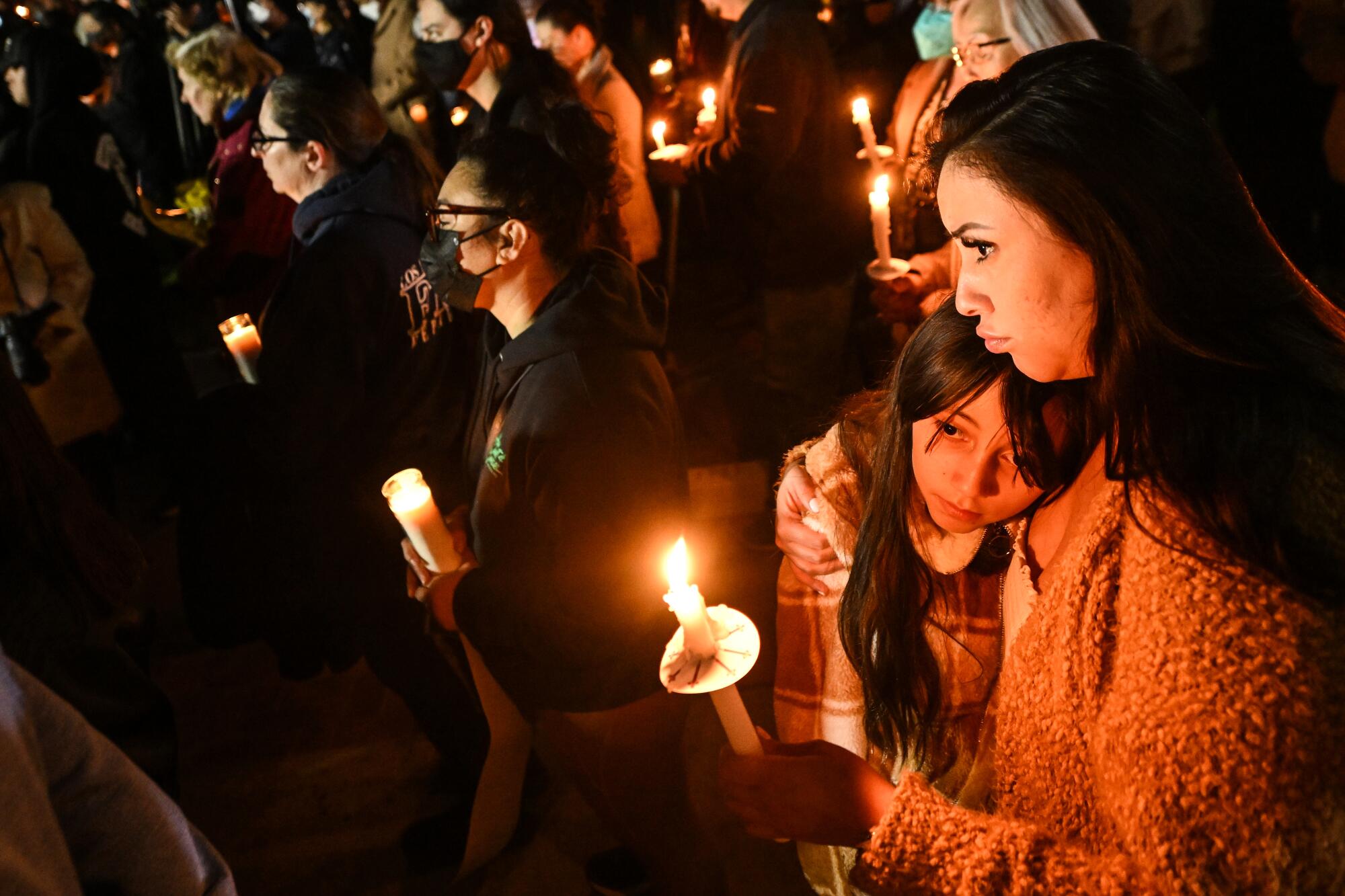 Mourners hold candles during a vigil in Monterey Park.