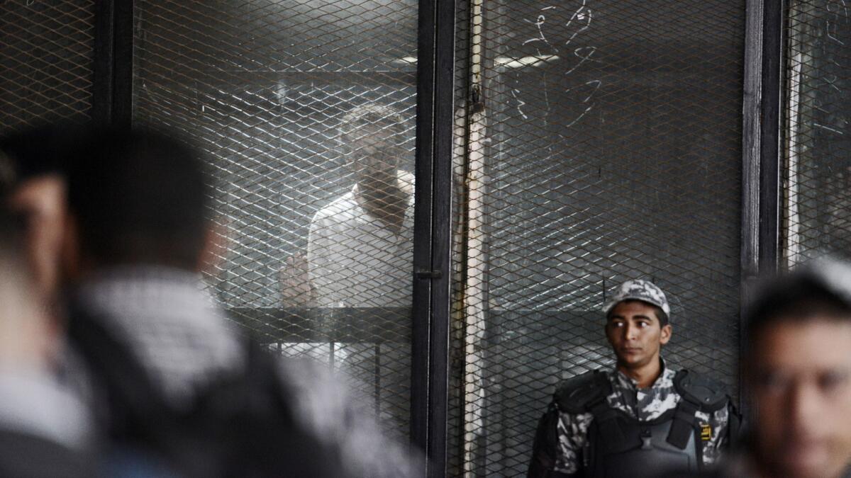 Photojournalist Mahmoud Abou Zeid is seen behind bars during a court hearing July 28, 2018. He is one of the more than 700 defendants in a political mass trial in Cairo for whom the "maximum penalty" of death by hanging was requested by the prosecution.