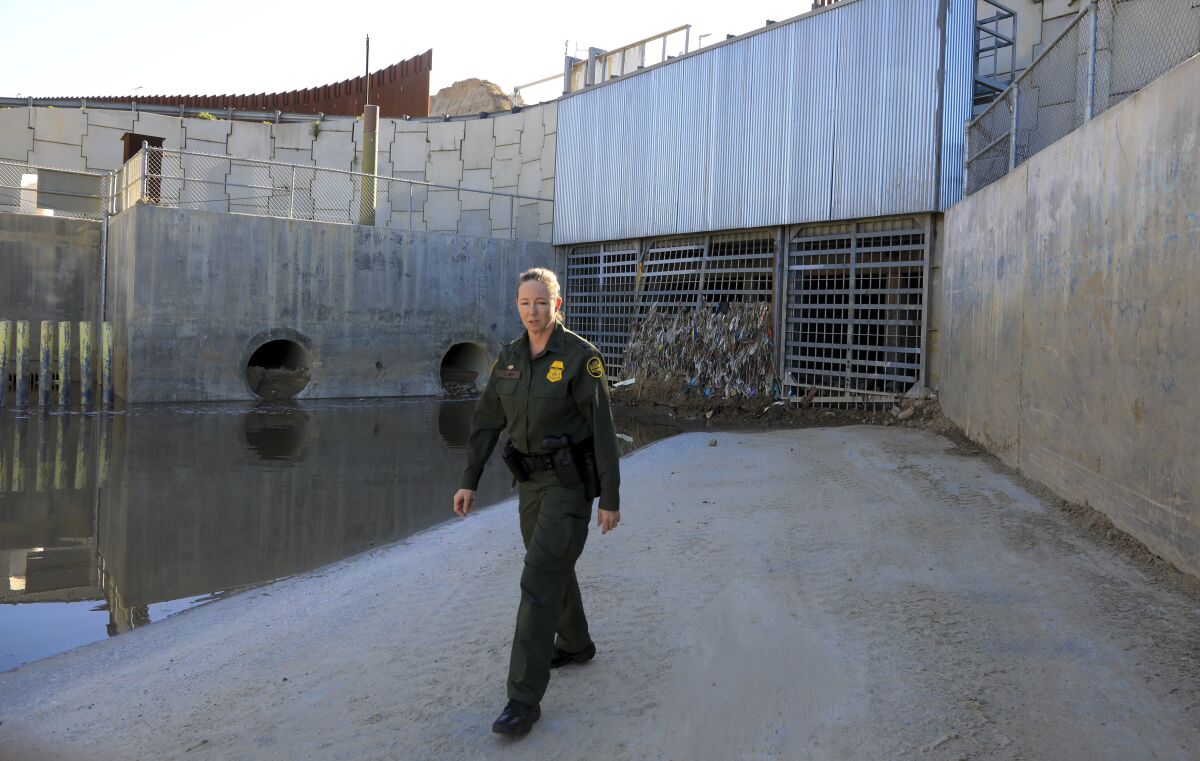 Border Patrol Agent, Amber Craig walks pass the storm culvert located at Goat Canyon along the U.S. Mexico border. When their are large flows of storm water the culvert steel grates are open allowing debris from the south of the border to enter into the United States.