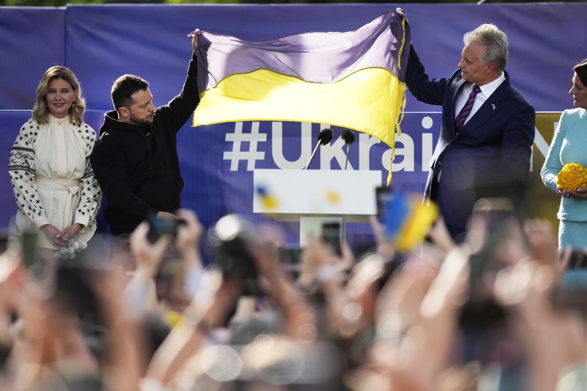 Ukrainian President Volodymyr Zelensky, left, and Lithuanian President Gitanas Nauseda hold up a Ukrainian flag.