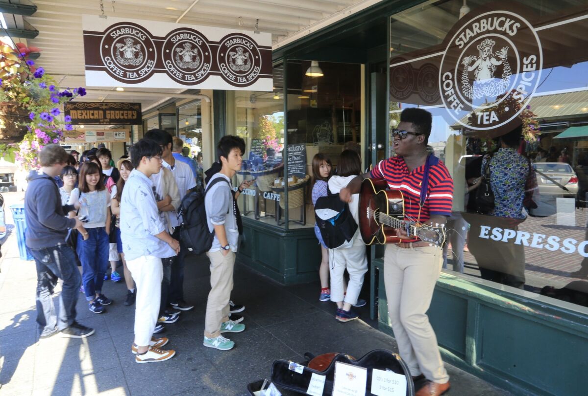 The original Starbucks (well, almost original; the original original is gone) in the Pike Place Market in Seattle is a popular tourist attraction. A rotating roster of musicians performs for the crowd from assigned positions.