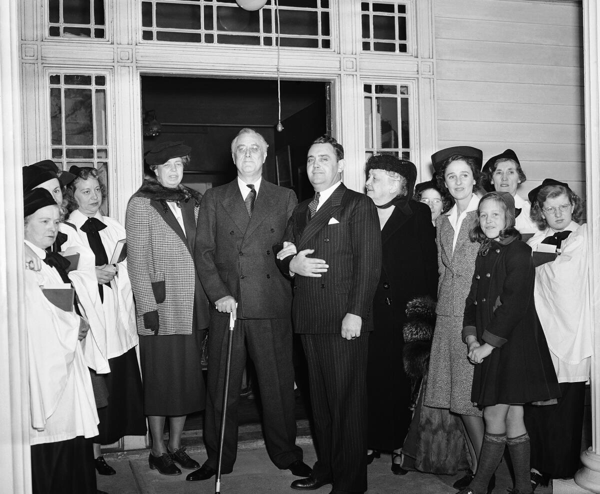 President Franklin Roosevelt is flanked by wife Eleanor, left, and an aide and family members in New York on Nov. 21, 1940.