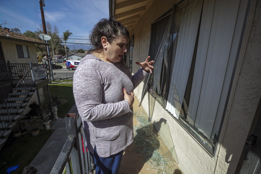 Jennifer Nalbandian stands outside her apartment amid shattered glass