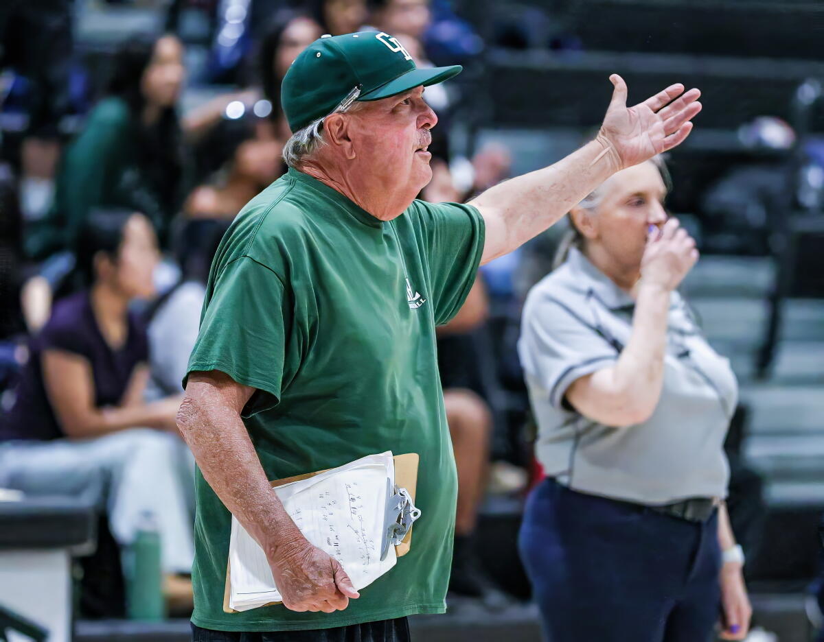 Tom Harp, the longtime girls' volleyball coach at Granada Hills High, gestures with his left arms raised along the sideline.