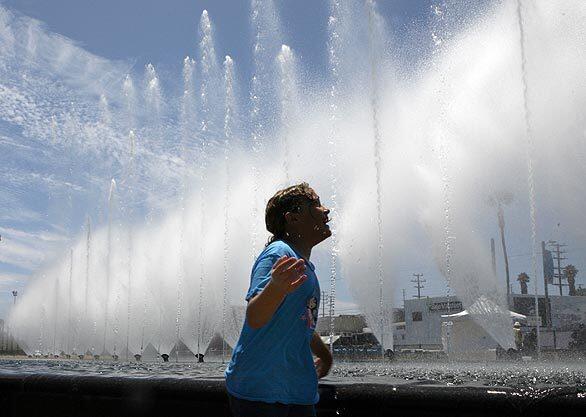 Mekenzie Marsh enjoys the spray from the new Las Vegas-style fountain near the waterfront in San Pedro. Community opinion about the glitzy, $14-million showcase is divided.