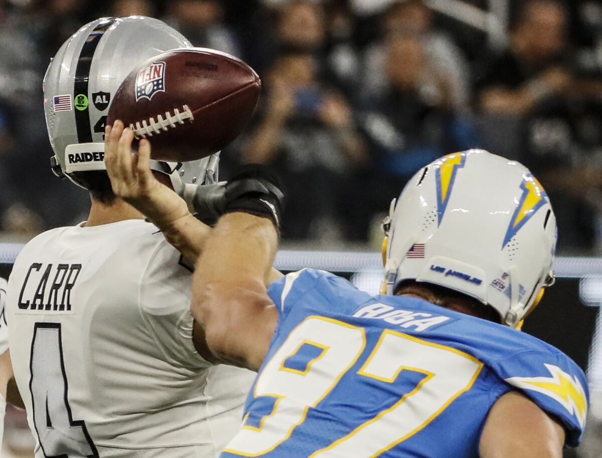 Chargers defensive end Joey Bosa  records a strip/sack on Raiders quarterback Derek Carr during the first half.