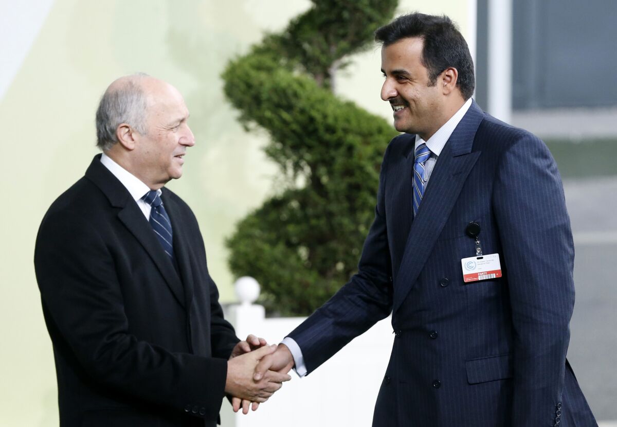 French Foreign Affairs minister Laurent Fabius, left, greets Qatar's Emir Tamim bin Hamad Al Thani as he arrives for the COP21, United Nations Climate Change Conference, in Le Bourget, outside Paris, Monday, Nov. 30, 2015. (Guillaume Horcajuelo/Pool via AP)