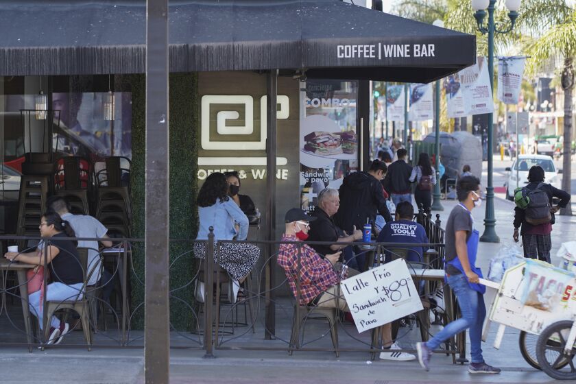 Tijuana remains on "red light" - the highest COVID-19 level of alert but the health secretary says Tijuana will be going to orange soon. June 18th, 2020 in Downtown Tijuana. Customers sit outside Cafe Baristi coffee shop on Avenida Revolucion.