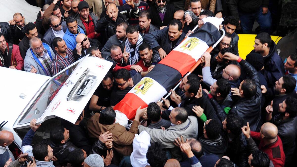 People carry the coffin of an activist who was killed when police broke up a rally near Tahrir Square commemorating the 2011 protests which led to the fall of the Mubarak regime.