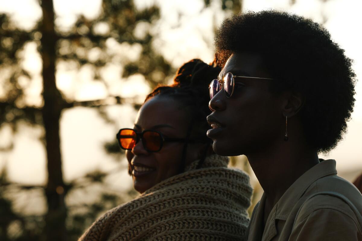 Nia Lee, left, and Beyond, right, listen to poetry readings at sunset.