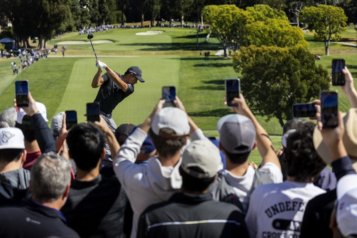 Fans hold up their phones to capture Collin Morikawa of La Cañada teeing off at the Genesis Invitational.